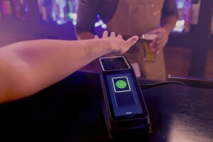 A photo of a customer paying for a beer at a bar using Amazon One.