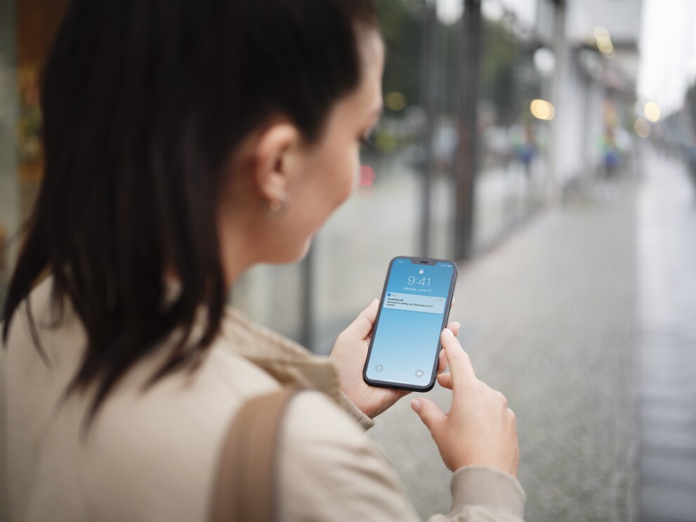 Frau sieht Benachrichtigung auf ihrem Mobiltelefon