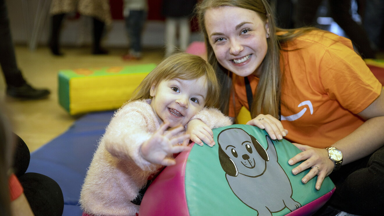 Bethan, a toddler with congenital Heart Disease and an Amazon worker from the Tilbury fulfilment centre, smile at the camera.