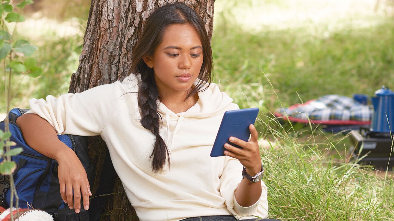 An image of a person reading on a Kindle device