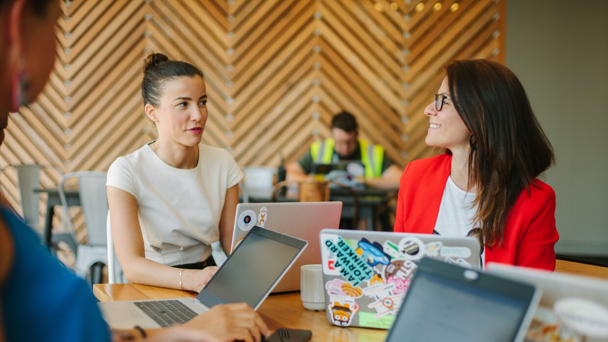 colleagues at Amazon sat around a table with laptops
