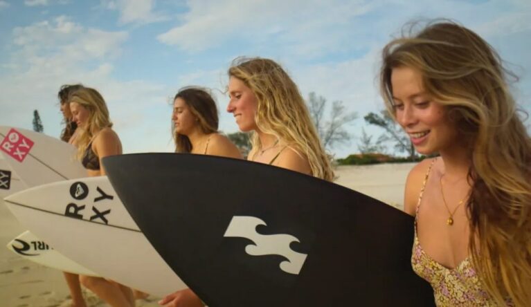 Alle Surfer Mädchen mit Surfboard in der Hand am Strand