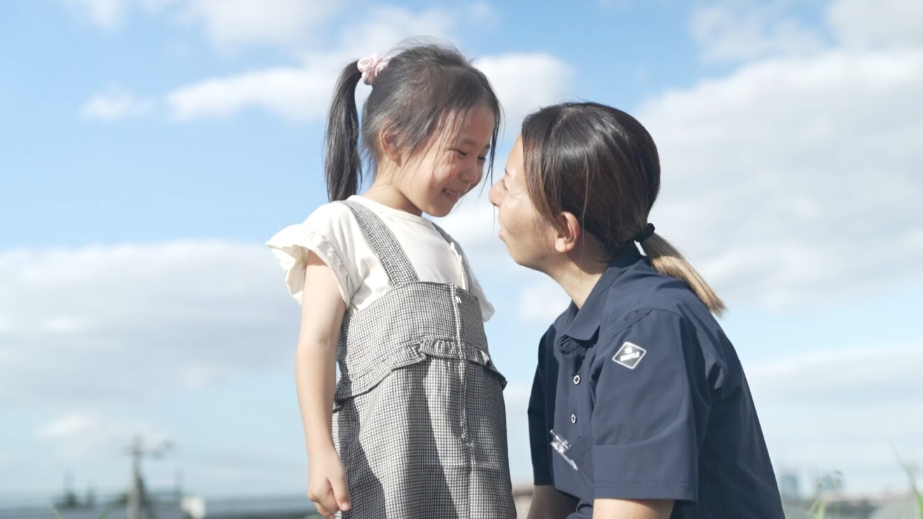 青空の下、楽しそうに笑顔で見つめあう宮本さんとお子さん