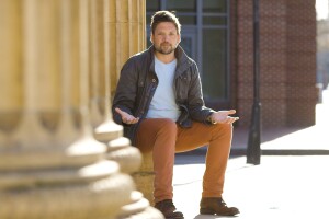 AWS Startup Evangelist Mackenzie Kosut sitting against a wall