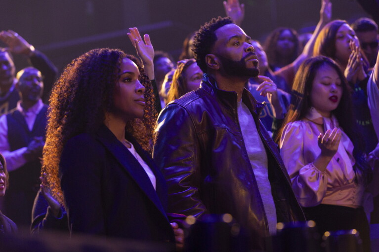 Two people in purple lighting in a crowd