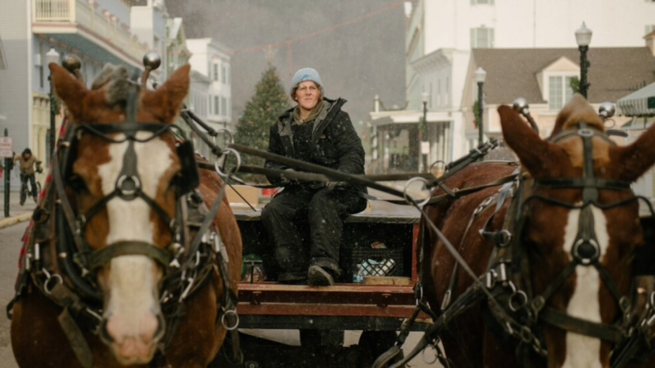 A woman riding a horse on Mackinac Island, Michigan to deliver Amazon Pharmacy medicine
