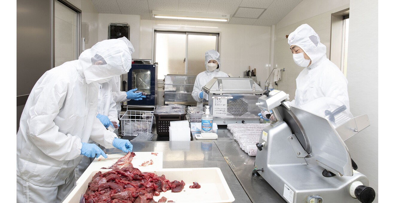 調理加工用の服で身を覆ったスタッフさんたちが肉の加工にあたる様子