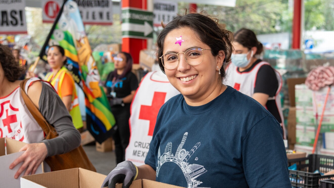 Voluntaria de Amazon encajando productos en cajas de la Cruz Roja.