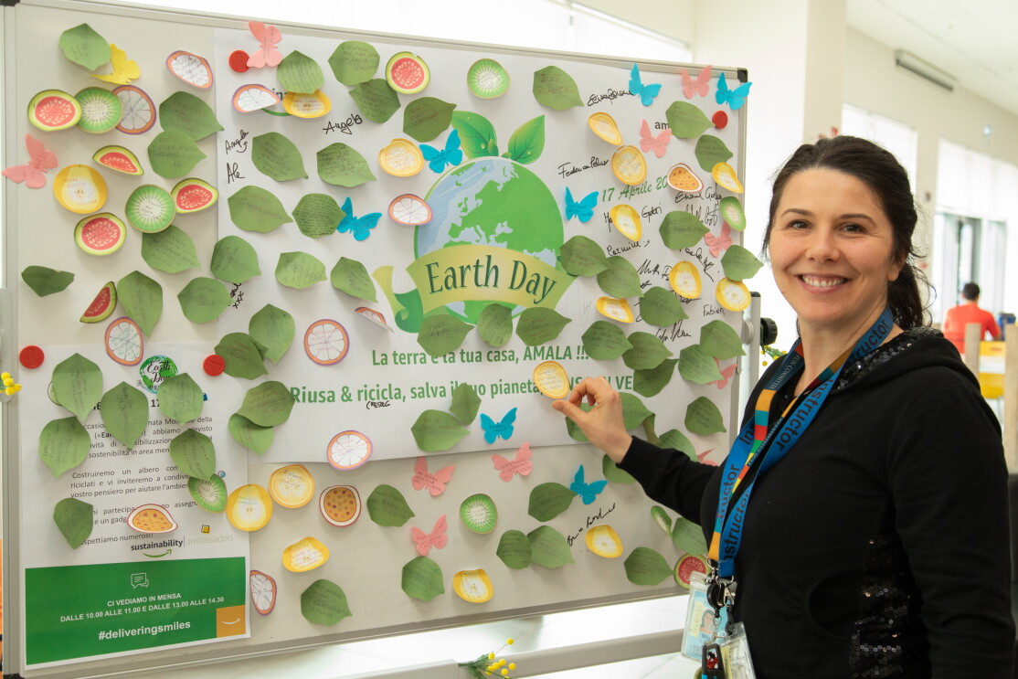 Dipendente del centro di distribuzione Amazon di Passo Corese attacca un post-it su una lavagna in occasione dell'Earth Day