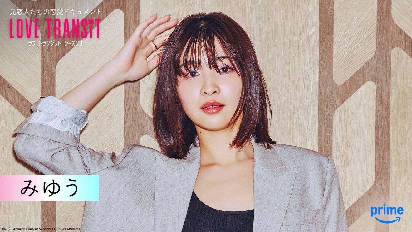 木目調の壁の前に立つ人物のバストアップ。薄いグレーのジャケットを着用、右手を挙げている。左上隅に「LOVE TRANSIT」の文字。左下に「みゆう」と名前が表示されている。