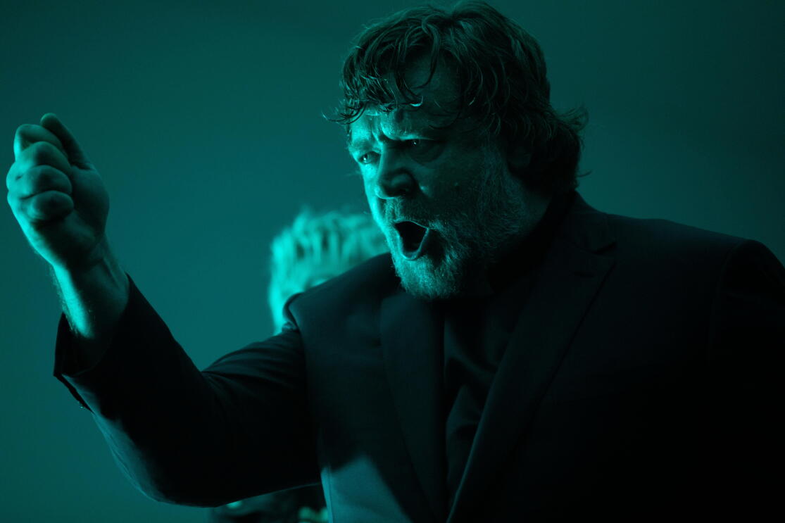 Homme barbu hurlant dans une lumière bleu-vert intense