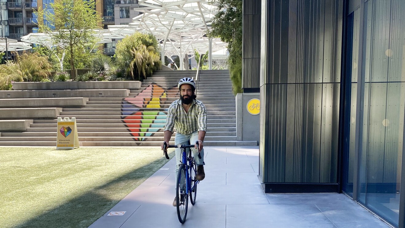 A man rides a bike wearing a helmet through the Amazon HQ in Seattle.