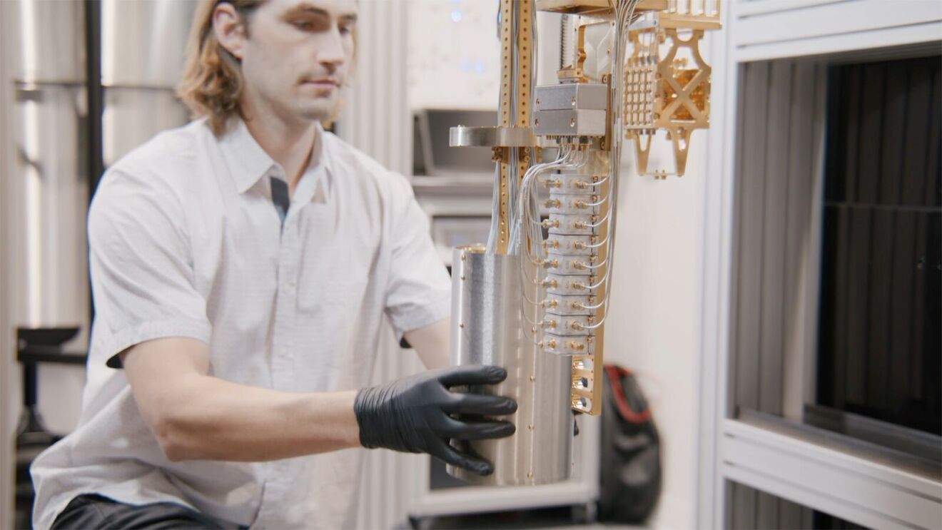 AWS ocelot computing chip: Researcher examining intricate tubing system in lab