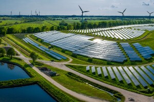 An image of solar panels in a farm full of bright green grass. 