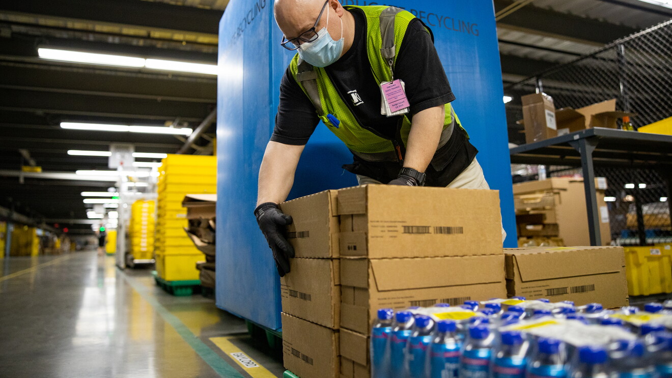 Amazon associate packs or unpacks boxes in a fulfillment center
