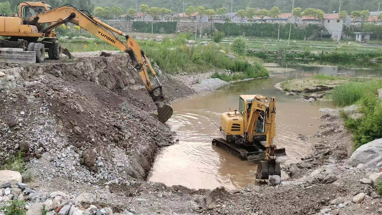 Two tractors digging in the Miyun Reservoir, China.
