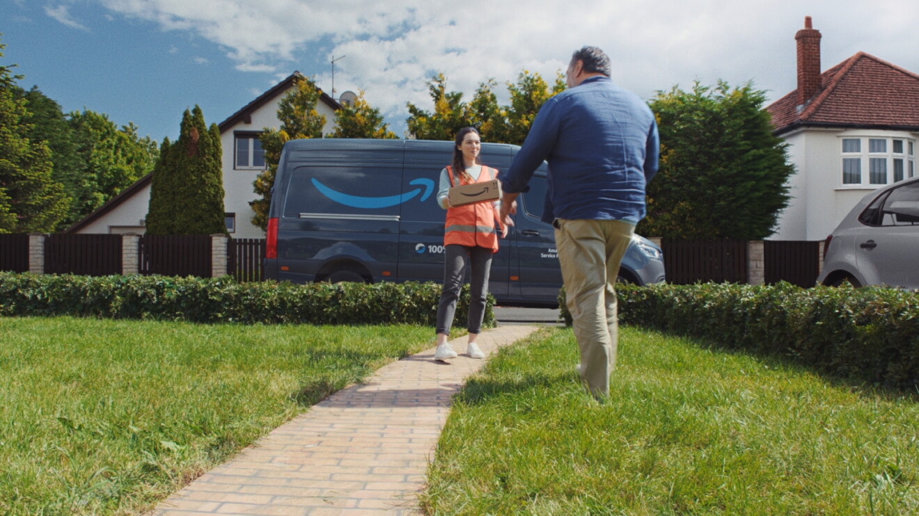 Driver hands parcel over to customer on front lawn