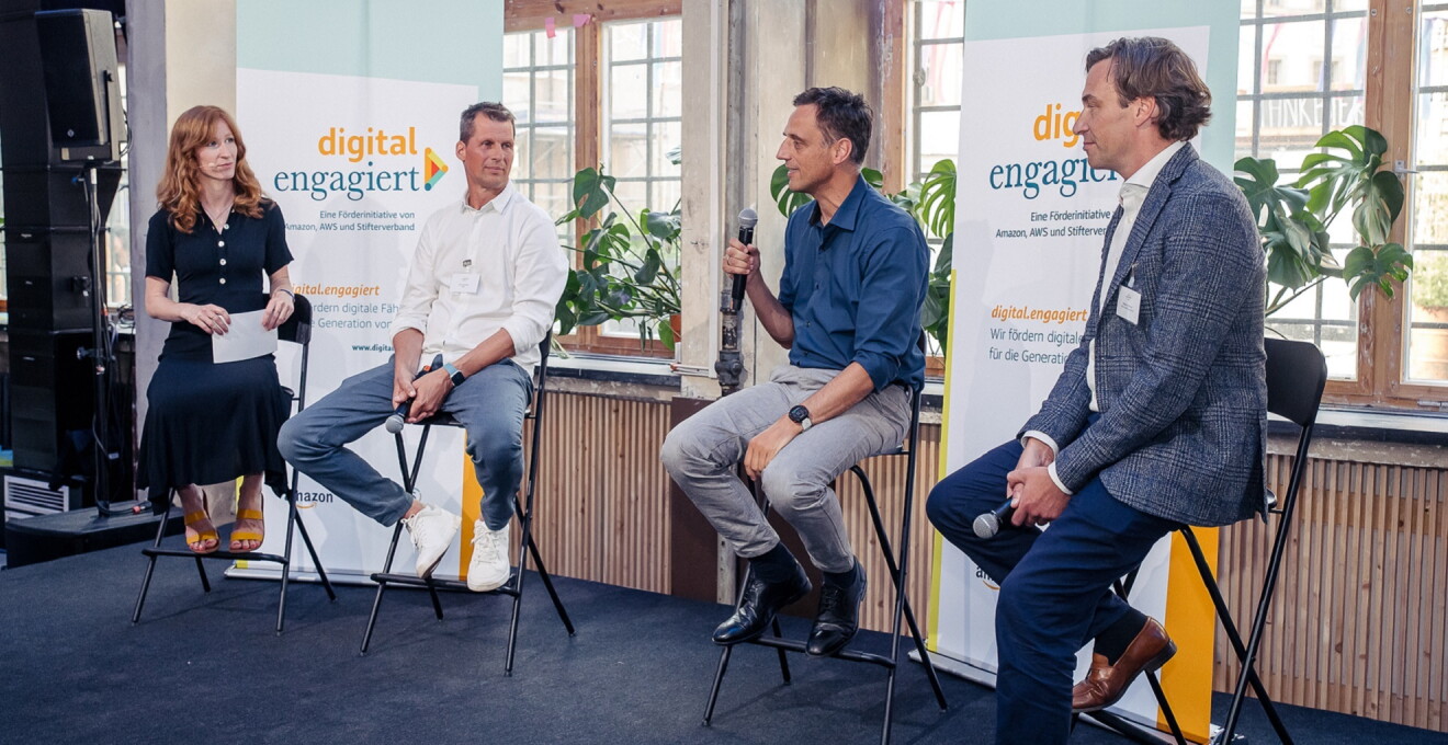 Moderatorin Teresa Sickert, Lars Schmitz (Amazon Web Services), Rocco Bräuniger (Amazon) und Holger Krimmer (Stifterverband) (v.l.) sitzen auf der Bühne der digital.engagiert-Abschlussveranstaltung und tauschen sich aus.