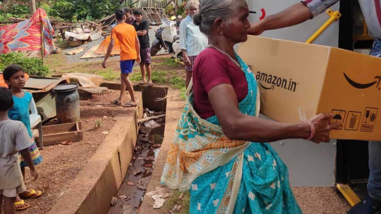 An old woman receiving Disaster Relief package from amazon india