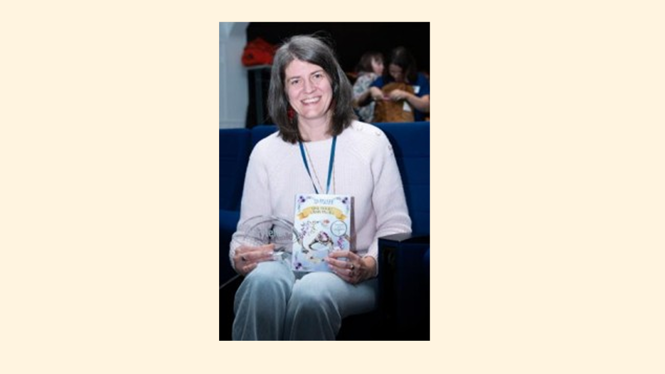 Femme souriante tenant un prix et un livre 