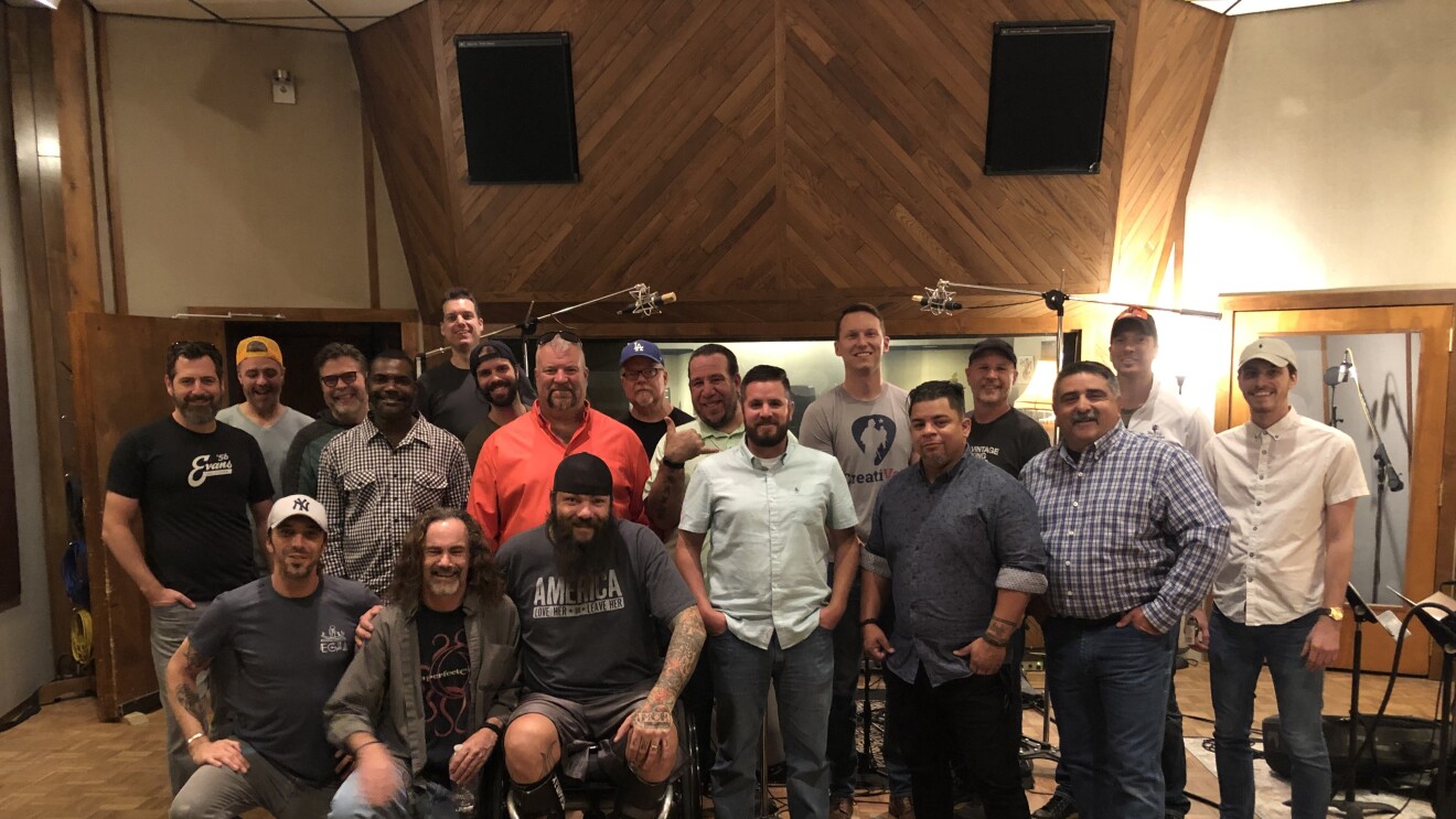 A group of men gather inside a recording studio (image taken before COVID-19 pandemic)