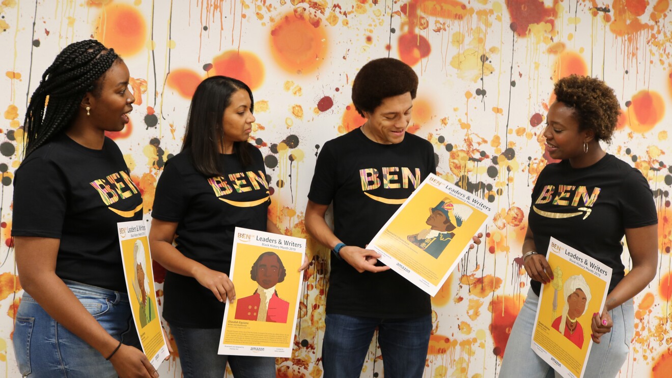 Amazon employees standing together and  discussing historic characters for Black History Month