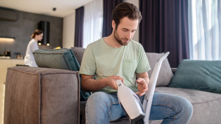 A man inspecting a vacuum cleaner