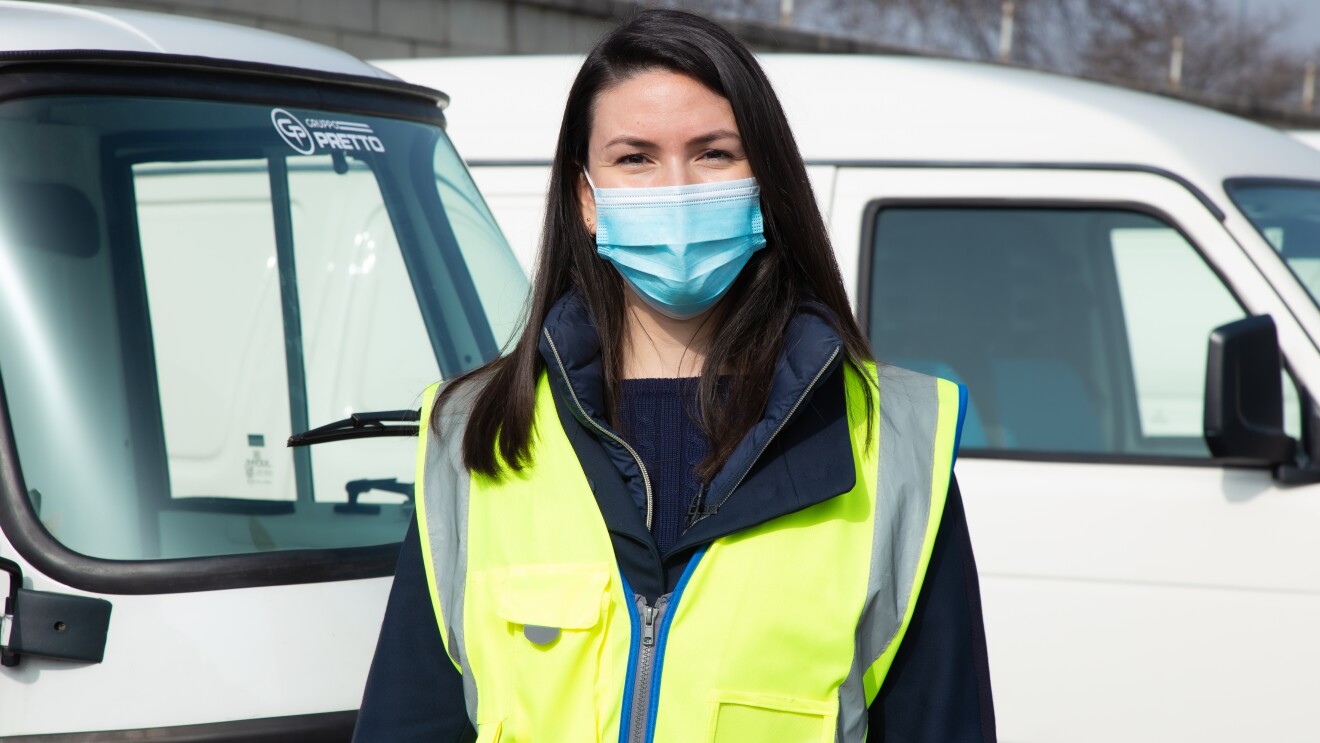 Micaela Moscarella posa davanti ad alcuni veicoli elettrici per le consegne Same Day