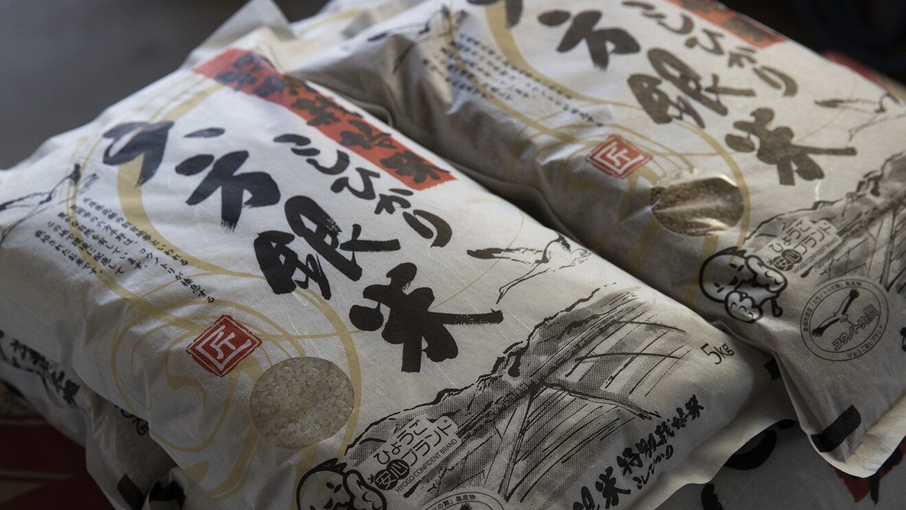 白い和紙のようなパッケージに水墨画のようなタッチで里山の風景が描かれているコシヒカリ「六方銀米」のパッケージ