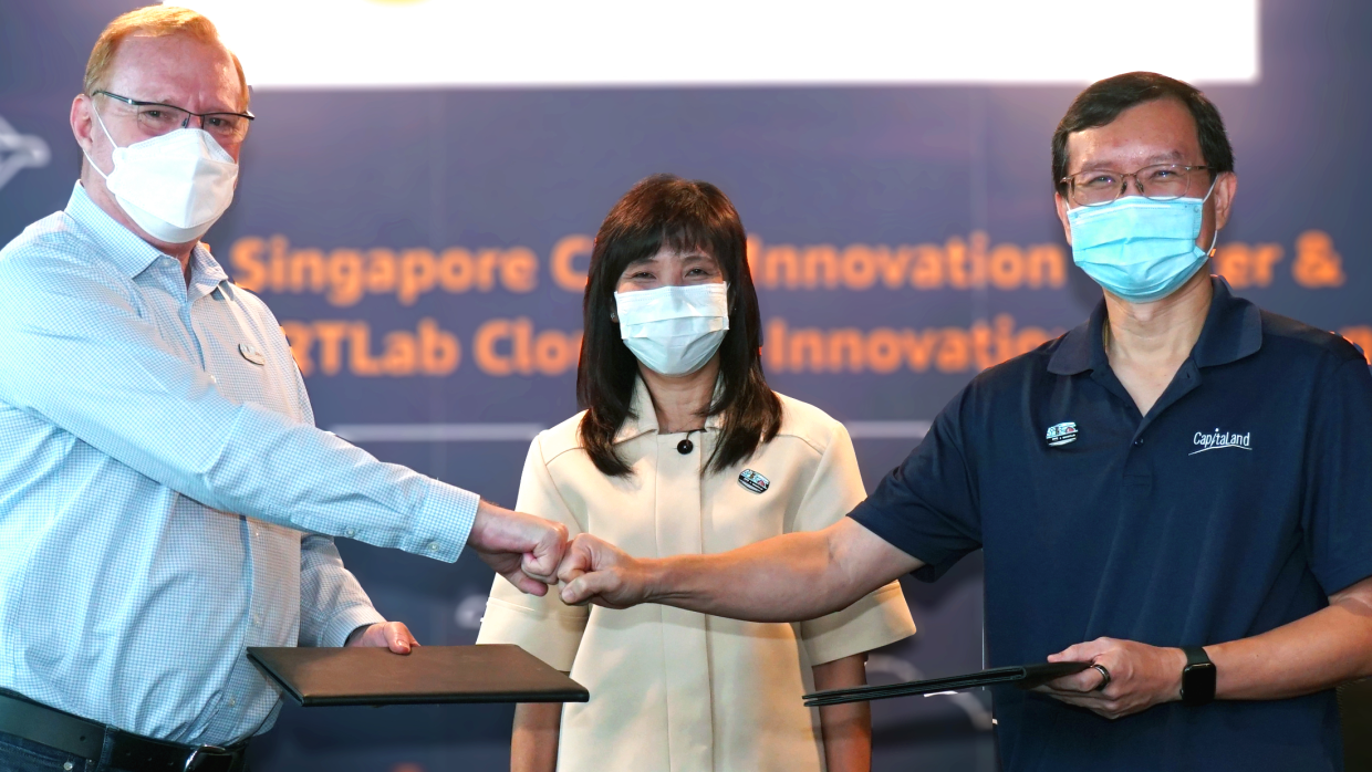 Executives from the AWS and Smart Urban Co-Innovation Lab fist bumping to celebrate the collaboration