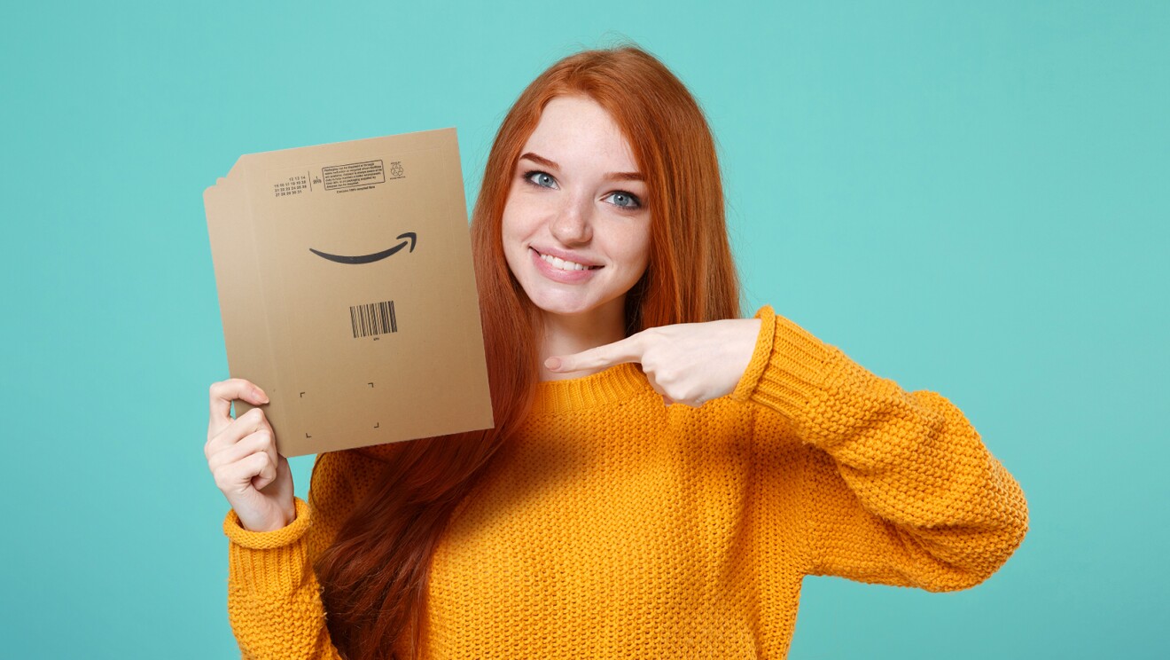 Una giovane donna tiene in mano una busta di carta riciclabile Amazon
