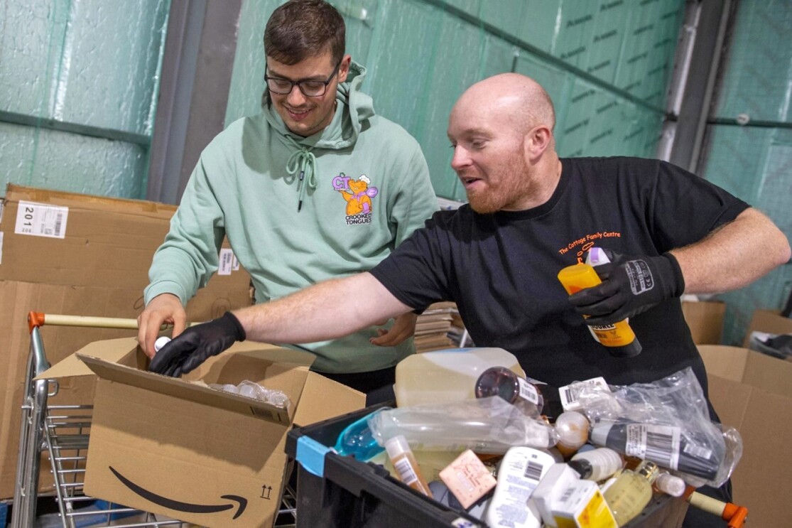 Two men putting items into boxes for donations