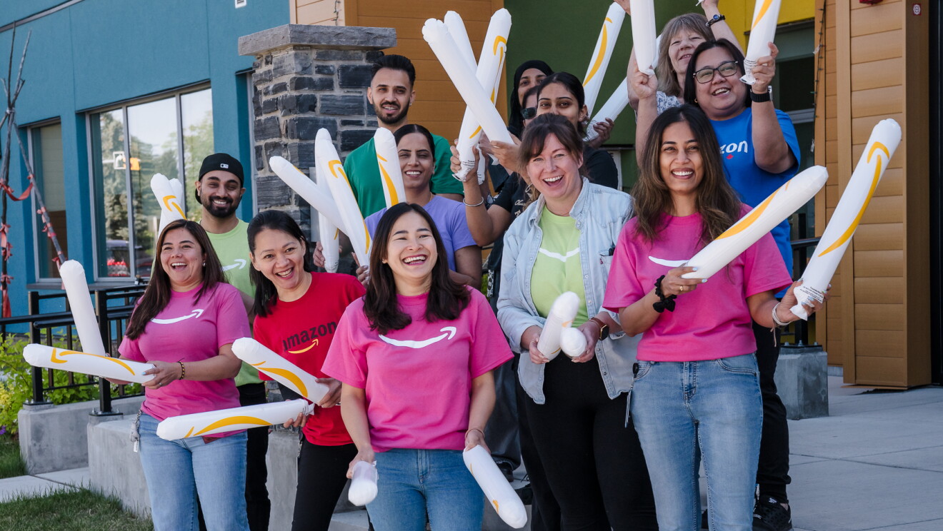 People smiling and posing wearing Amazon t-shirts.