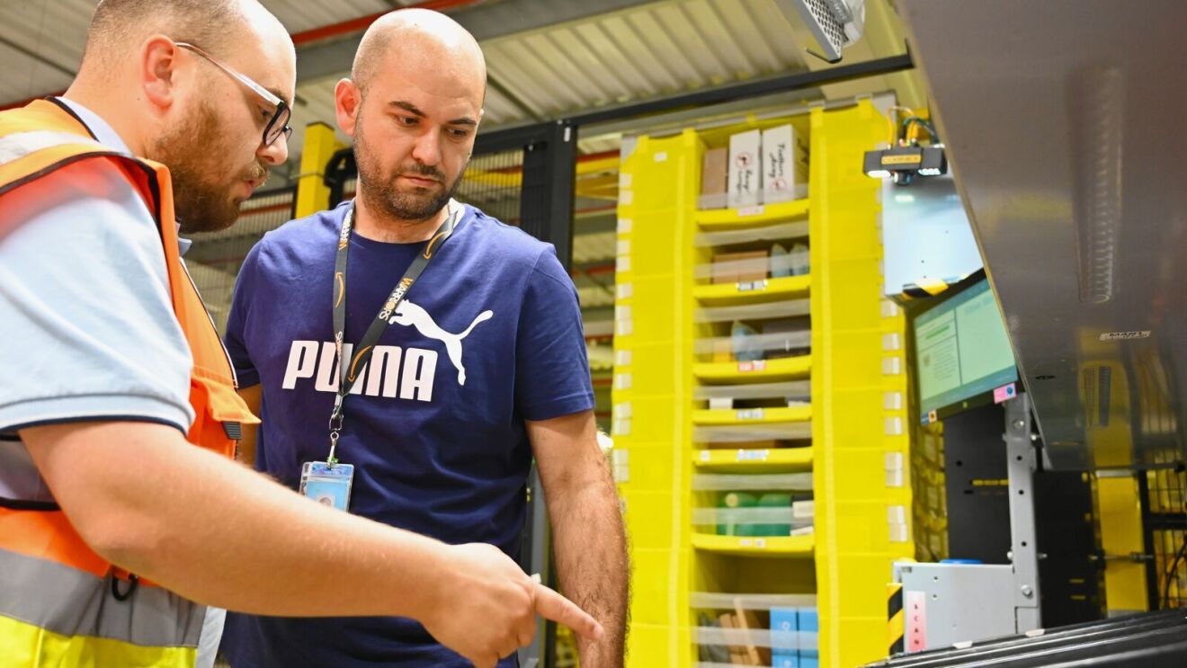 An area manager helping an employee with his tasks at the fulfilment centre 