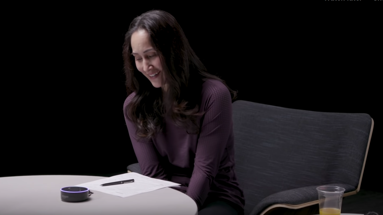 A woman looks at an Echo device while engaging with an Alexa social bot.