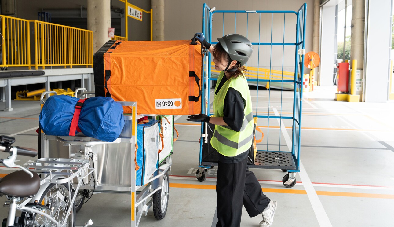 荷台に荷物を積み込む女性