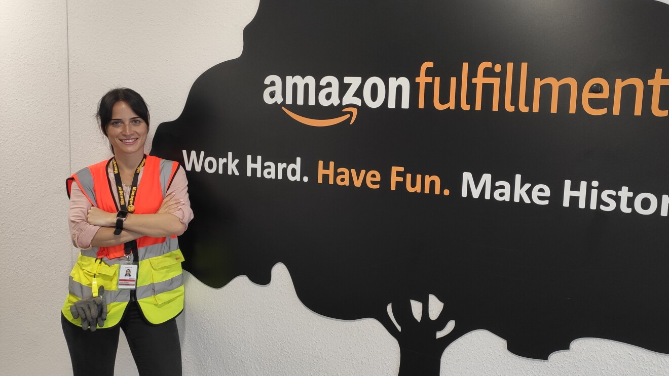 Salome in Sicherheitsweste vor einer Wand: Work hard, have fun, make history.