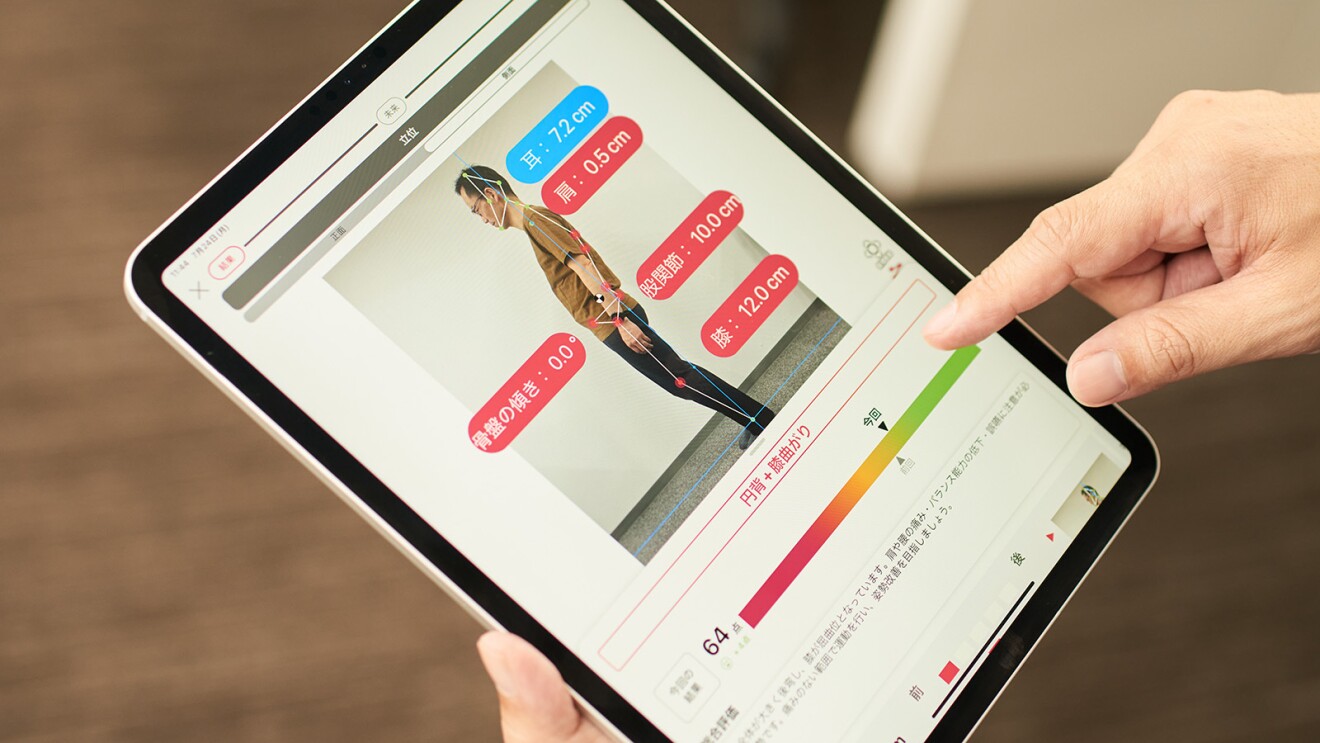 タブレットの画面に立っている人の側面からの画像。その上に膝や股関節などの幅などが表示されている
