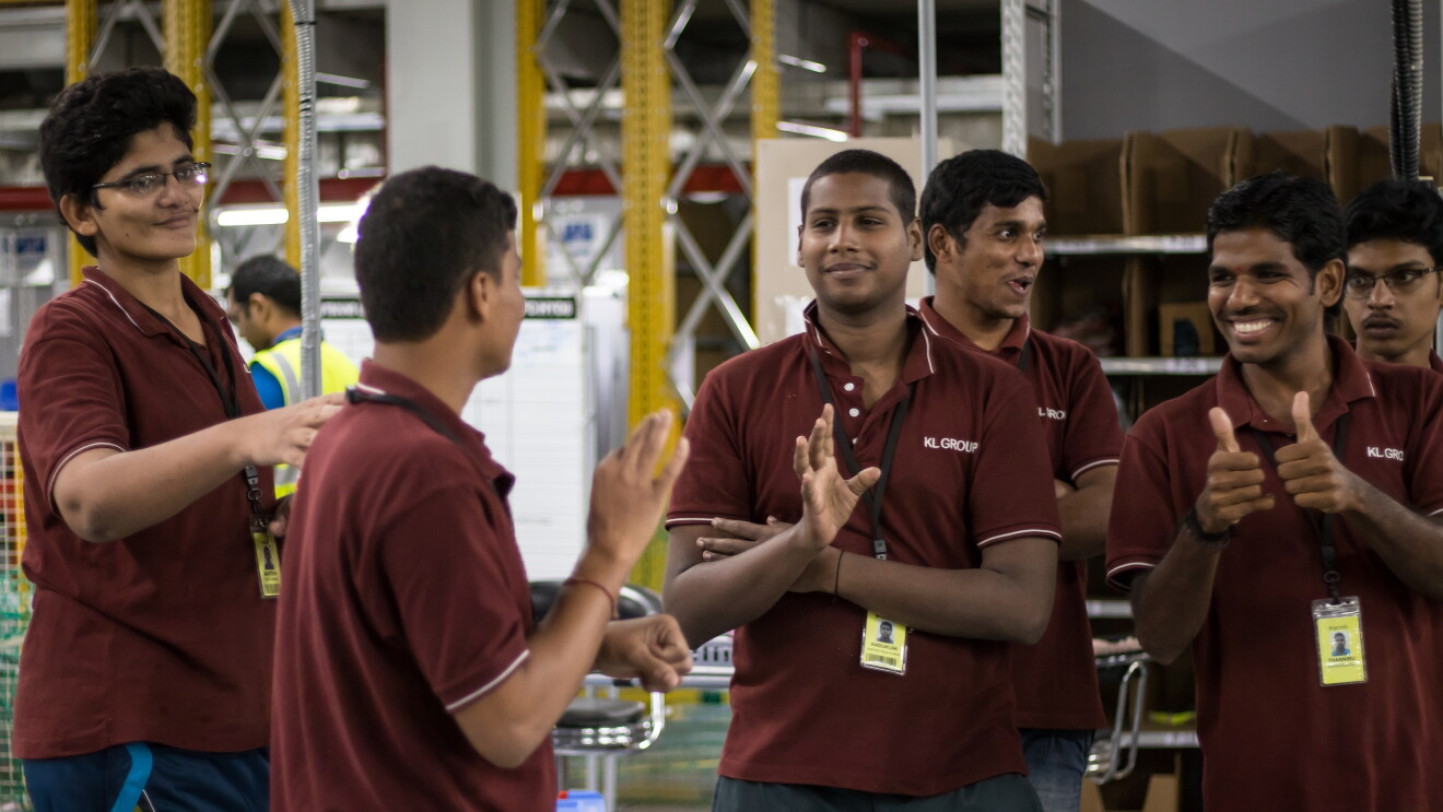 A group of differently abled assoicates interact with each other in sign language at a Fulfilment Centre