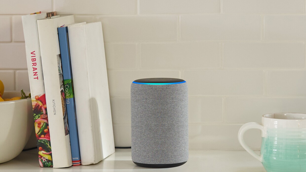 Echo device in a kitchen. To the left are cookbooks, to the right is a stoneware mug that fades from aqua to white. 