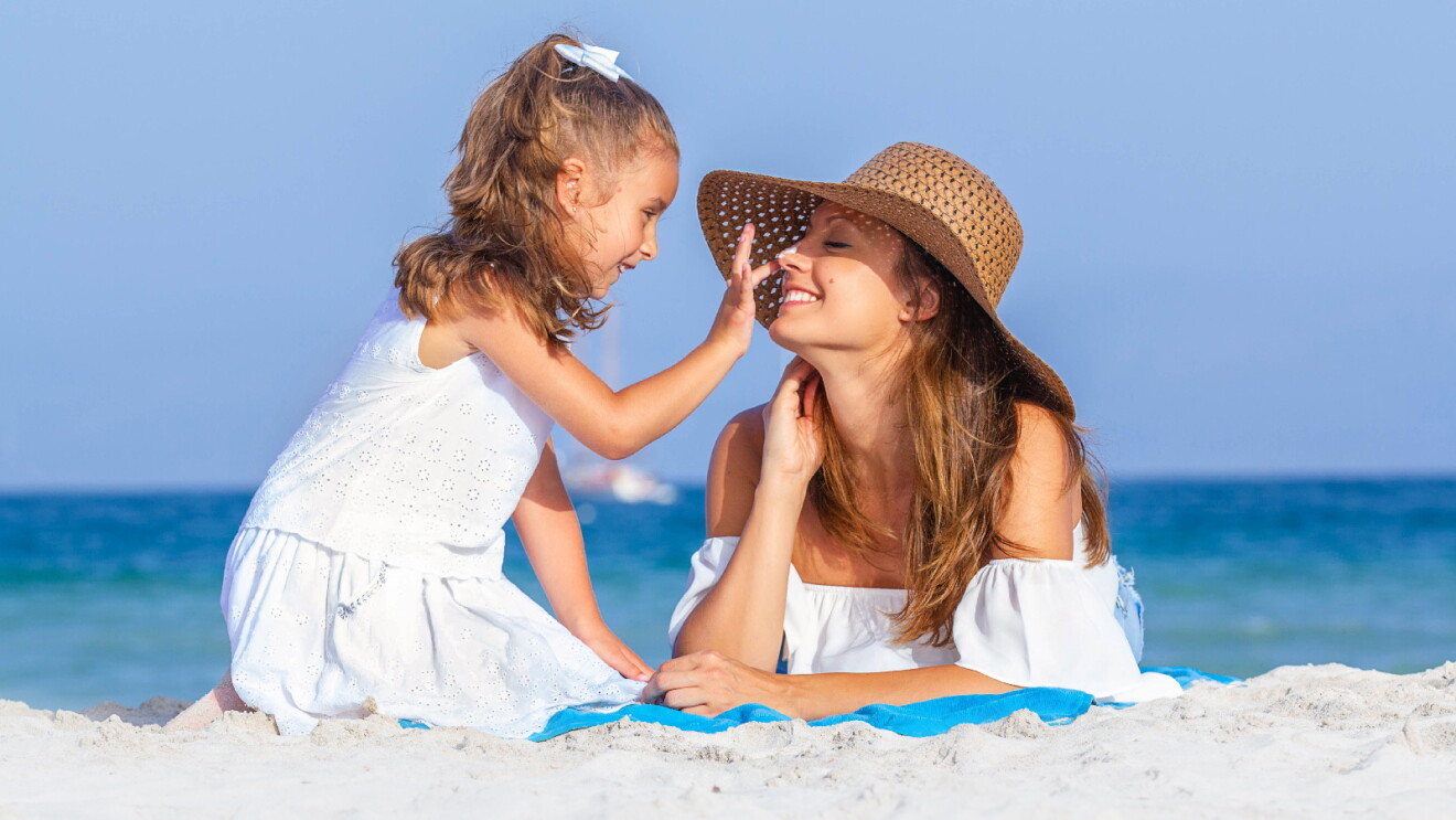 Prime Day 2023 live blog best deals: smiling mother wearing a floppy hat playing with her young daughter at the beach.