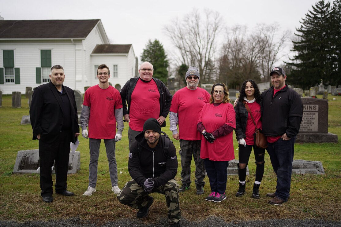 An image of Warriors@ members placing wreathes and flags on veterans' graves.