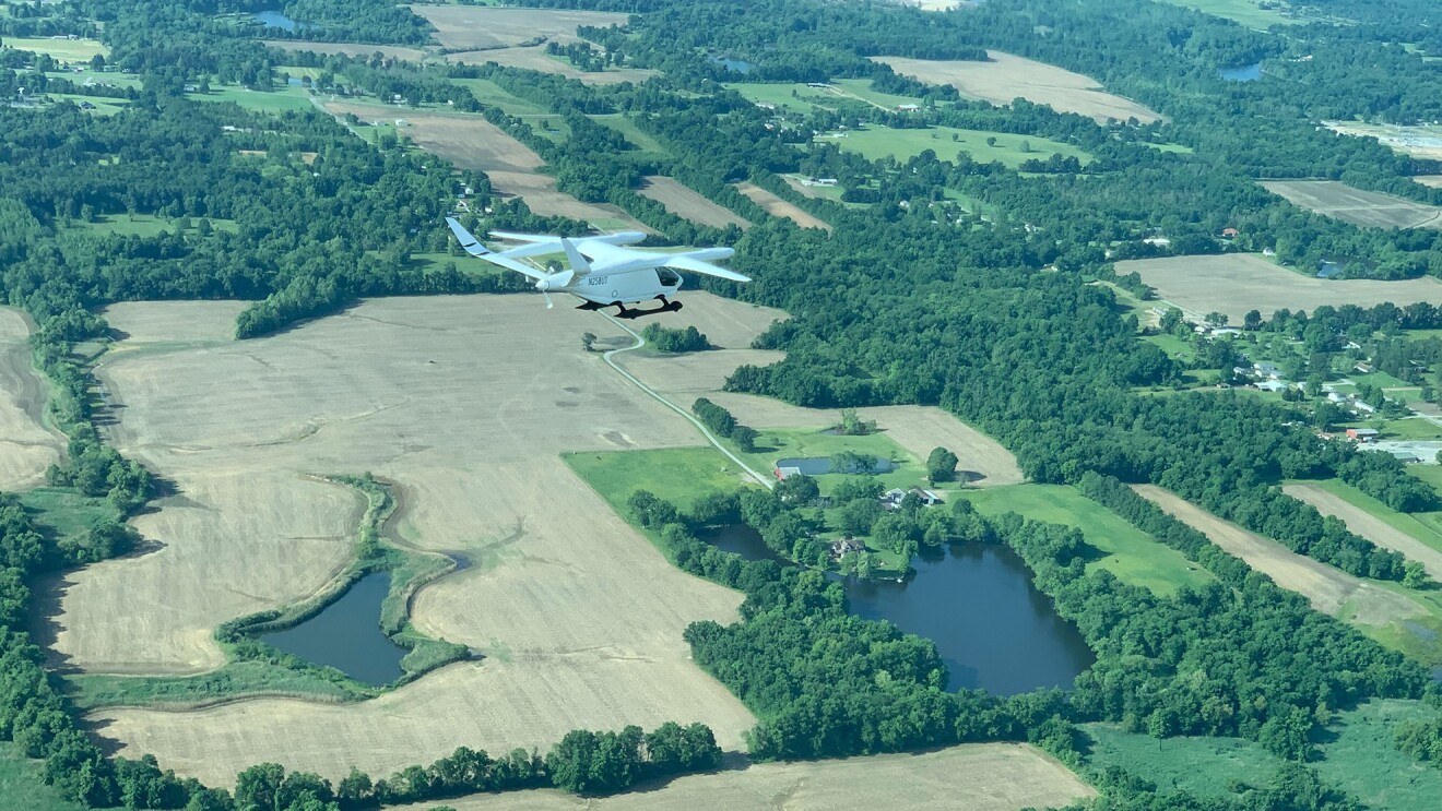 飞机飞过有小水体的陆地的鸟瞰图。