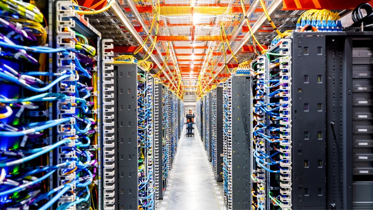 Data center with rows of servers and colorful network cables
