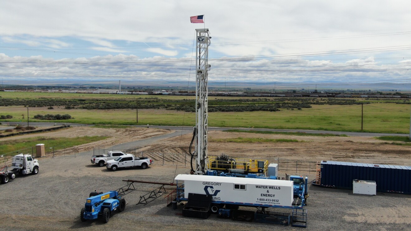 Drilling rig with American flag on rural landscape