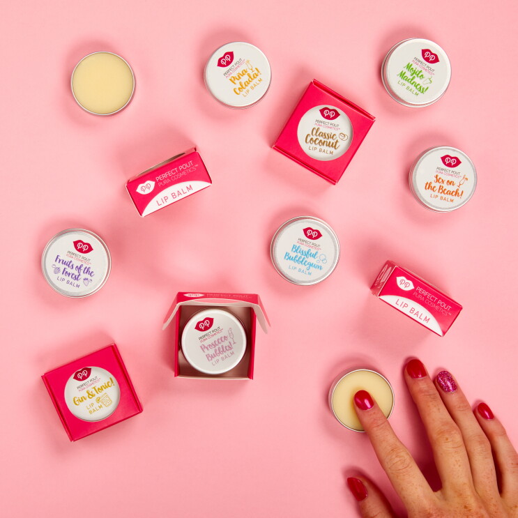 An image of the Pura Cosmetics large lips products in a pink table with someone using one of the products.
