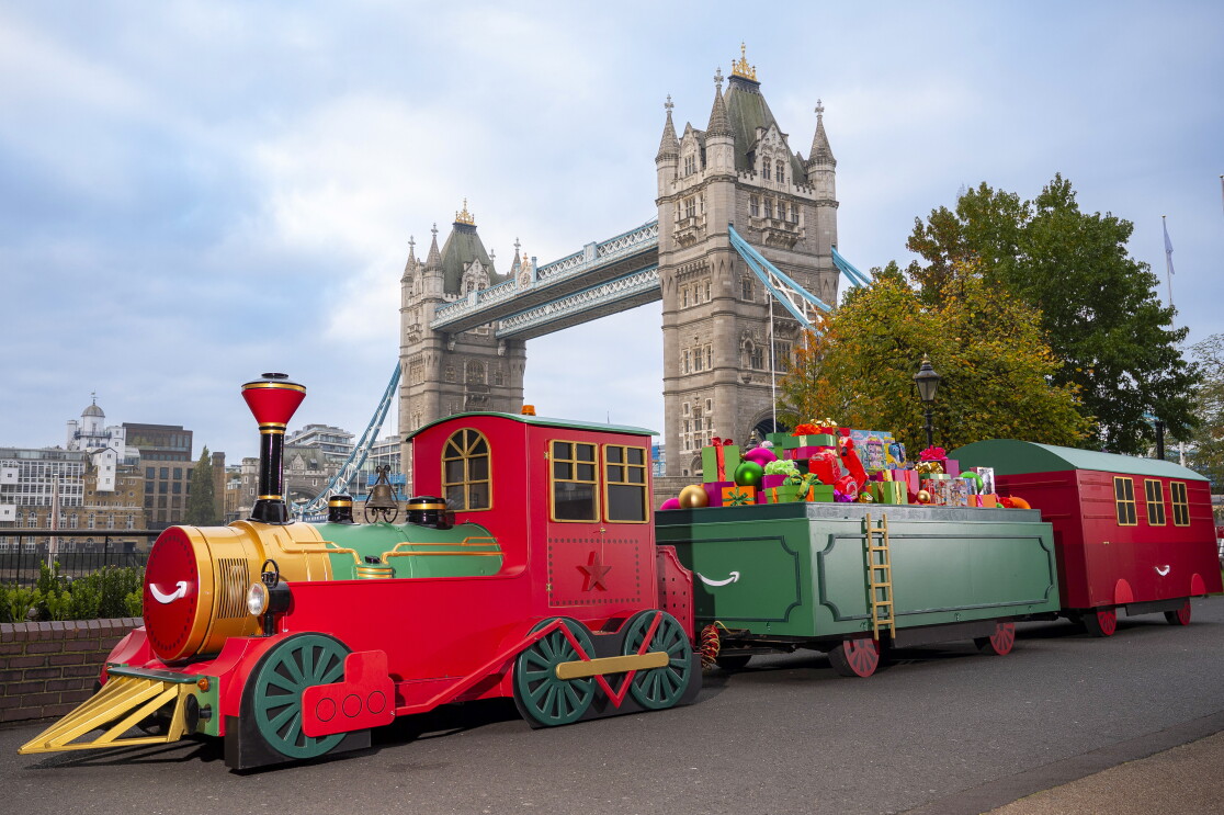 A toy train carrying toys with Tower Bridge in the background