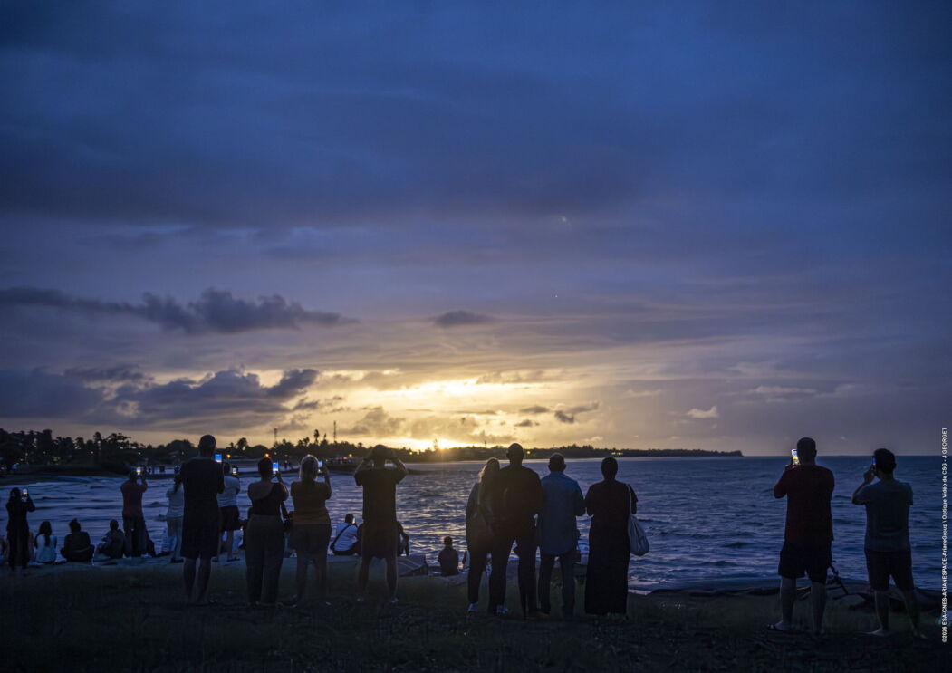 Crowd of people take photos of the Amazon LEO launching in the distance 