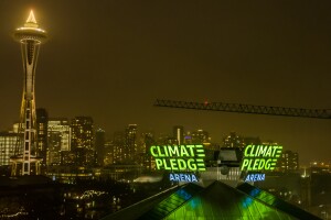 The Climate Pledge Arena signage lit up, with Seattle's Space Needle and skyline showing behind it.