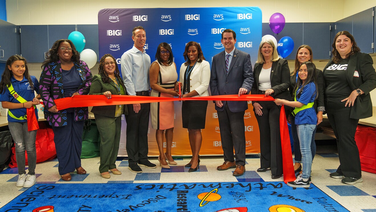 A photo of government and school district officials cutting the ribbon to the newly vamped AWS Think Big Space at River Oaks Elementary School.